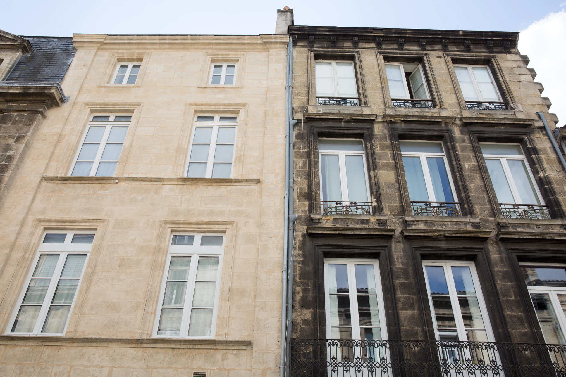 Façades d'immeubles historiques en pierre calcaire claire et grès sombre, architecture urbaine française traditionnelle