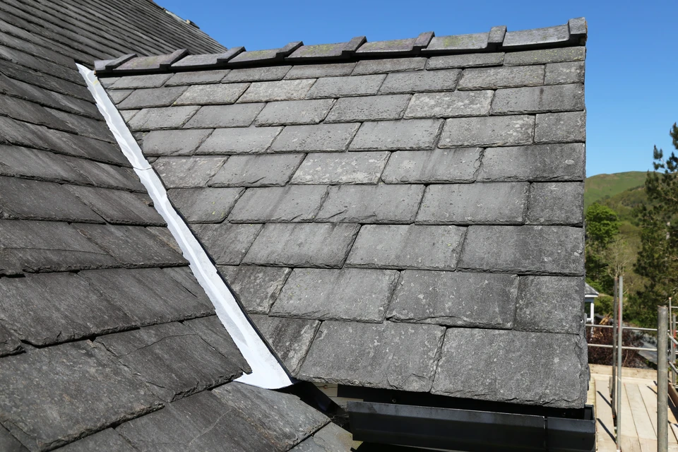 Vue en gros plan d'un toit en ardoise sur une fenêtre dorée d'une maison au Pays de Galles, Royaume-Uni