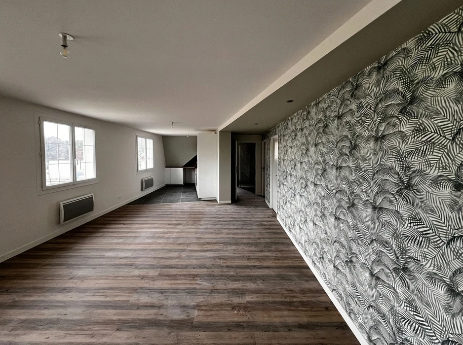 Appartement vide en cours de rénovation, pièce de vie lumineuse avec parquet stratifié imitation chêne