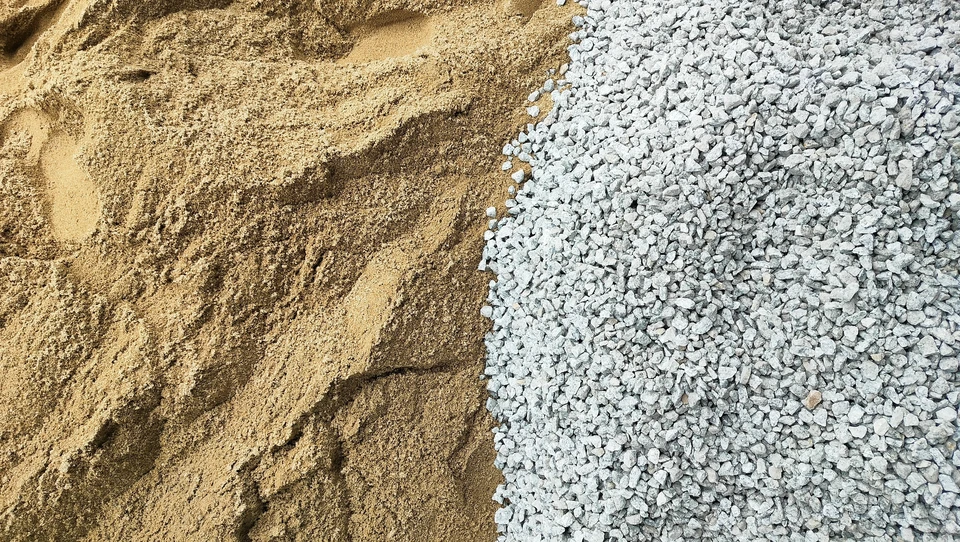 Espace de stockage extérieur avec nombreux big bags blancs aux sangles bleues disposés sur palettes en bois