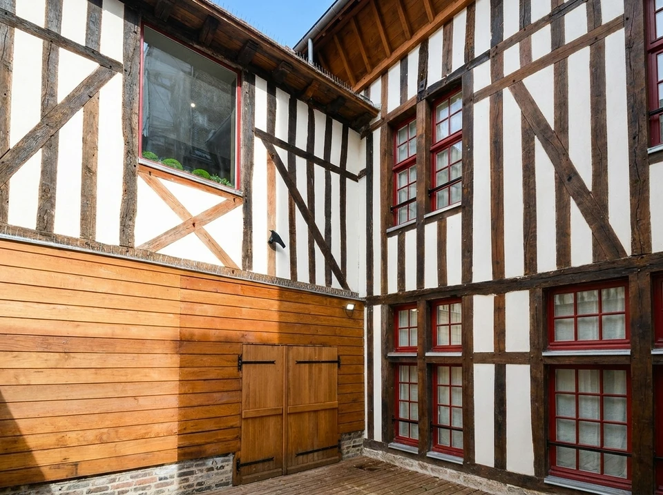 Chantier de démolition en extérieur avec pelleteuse hydraulique équipée d'un godet-pince démolissant une maison résidentielle